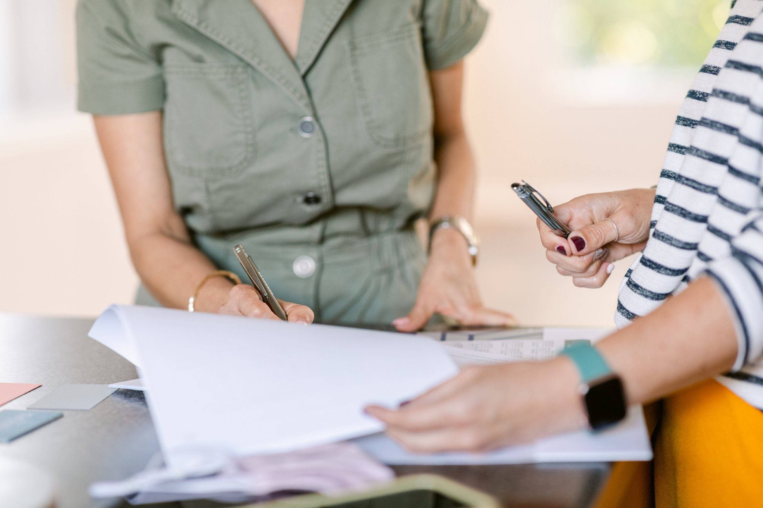 Two people writing on documents