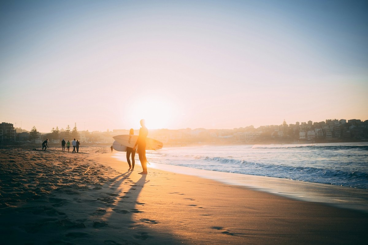 Surfers at sunrise on a beach