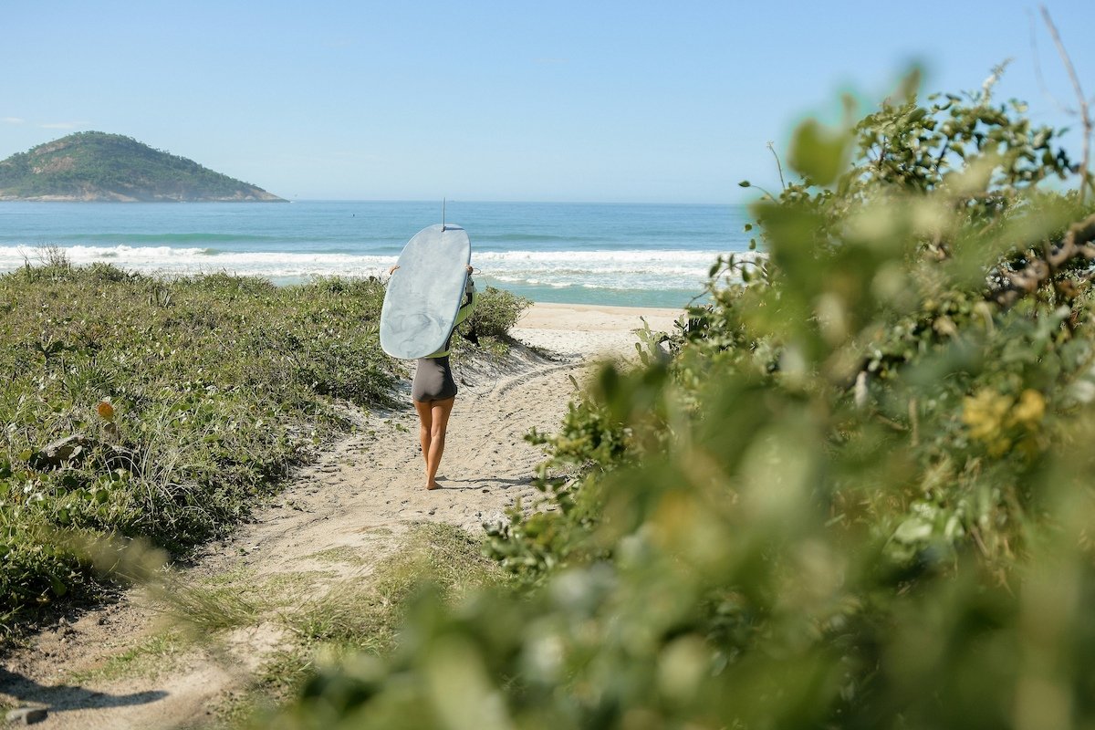 Woman with surfboard heading to the beach